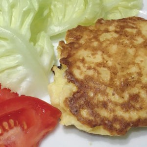 Galette de pomme de terre avec une feuille de salade et une tranche de tomate